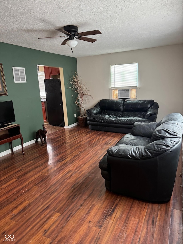 living room with dark wood-style flooring, ceiling fan, a textured ceiling, and baseboards