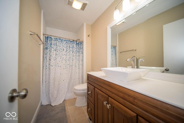 bathroom with toilet, vanity, and tile patterned floors