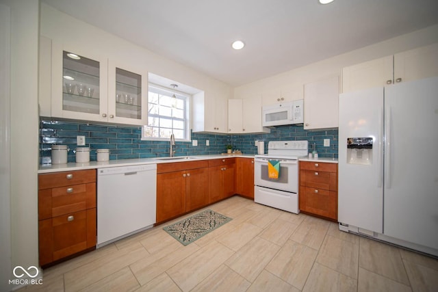 kitchen with white appliances, white cabinets, tasteful backsplash, and sink