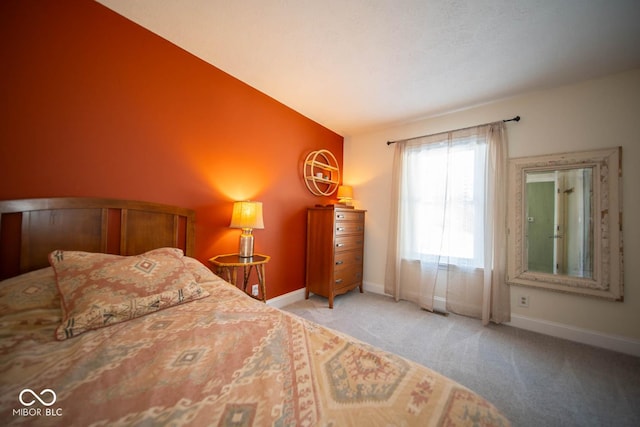 bedroom with lofted ceiling and light colored carpet