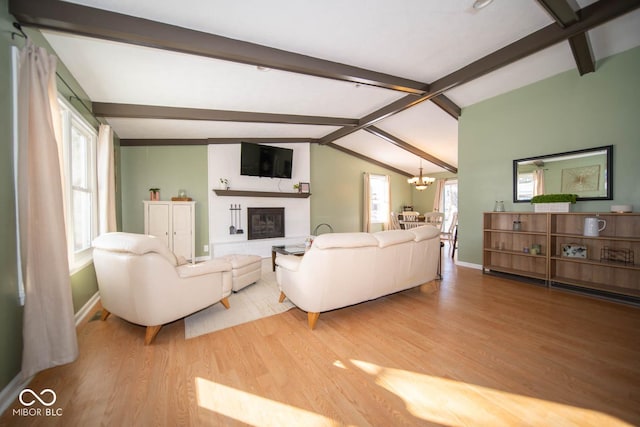 living room with an inviting chandelier, vaulted ceiling with beams, and hardwood / wood-style flooring