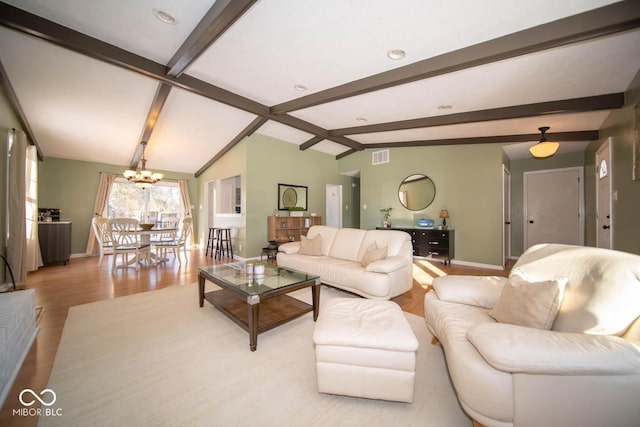 living room featuring light wood-type flooring, vaulted ceiling with beams, and a notable chandelier