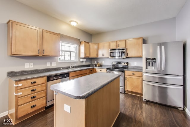 kitchen with dark wood-type flooring, appliances with stainless steel finishes, light brown cabinets, and a center island