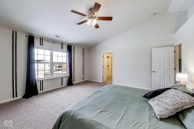 carpeted bedroom featuring ceiling fan, vaulted ceiling, and ensuite bath