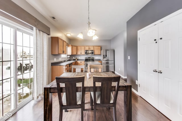 dining area featuring sink, an inviting chandelier, and dark wood-type flooring