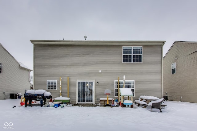 snow covered house with central AC