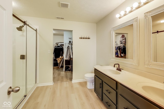 bathroom featuring walk in shower, toilet, vanity, and hardwood / wood-style flooring