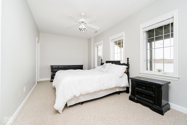 carpeted bedroom with multiple windows and ceiling fan