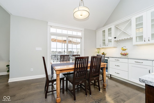 dining room with dark hardwood / wood-style flooring, lofted ceiling, and wine cooler