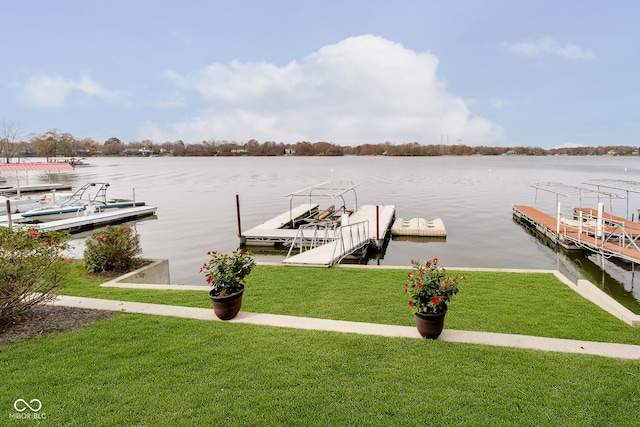 view of dock with a yard and a water view