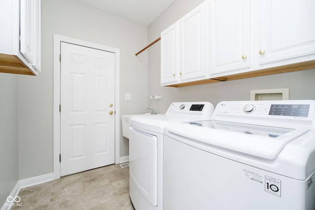 washroom featuring cabinets and washing machine and clothes dryer