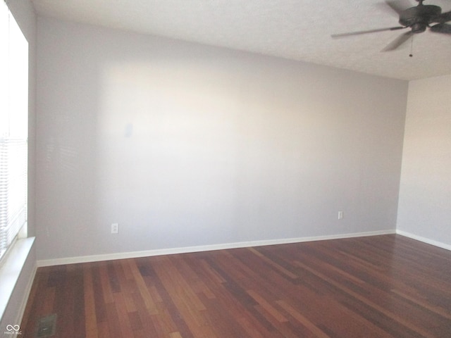 empty room featuring ceiling fan and dark wood-type flooring