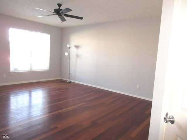 unfurnished room featuring ceiling fan and dark wood-type flooring