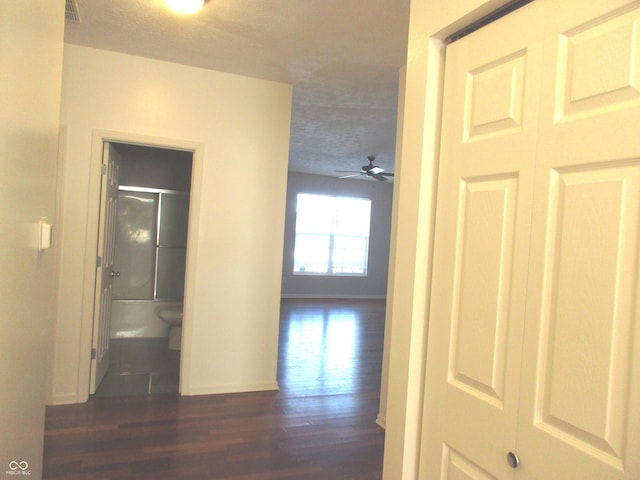 corridor featuring dark hardwood / wood-style flooring and a textured ceiling