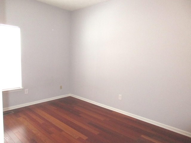 unfurnished room with dark hardwood / wood-style flooring