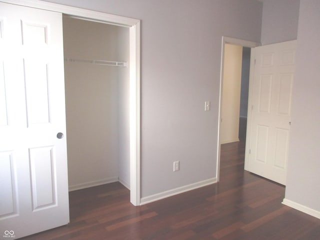 unfurnished bedroom featuring a closet and dark hardwood / wood-style floors