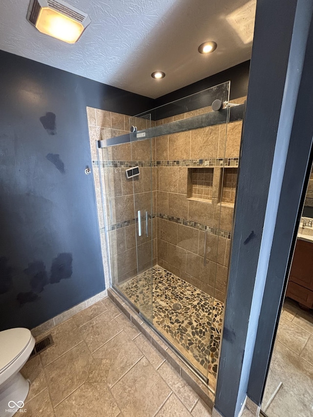 bathroom with toilet and a shower with door