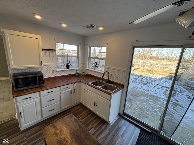 kitchen with dark hardwood / wood-style flooring, sink, white cabinetry, and a textured ceiling