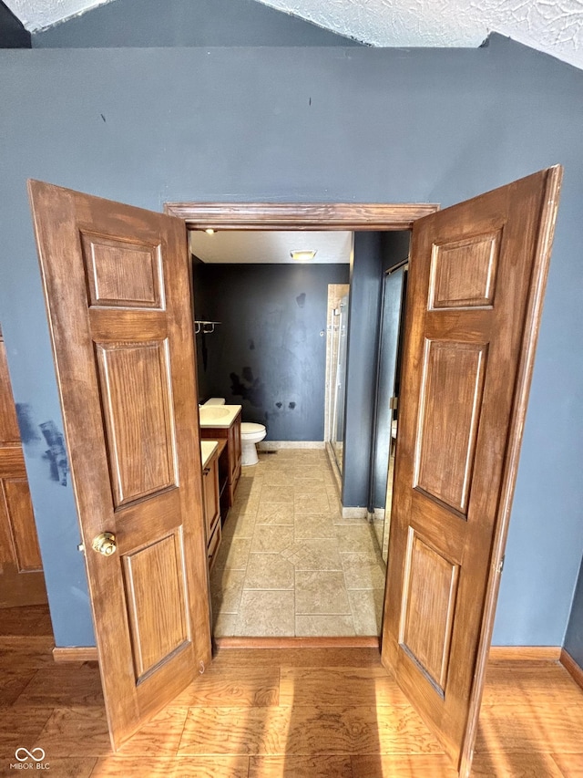 bathroom featuring a shower, hardwood / wood-style floors, and toilet