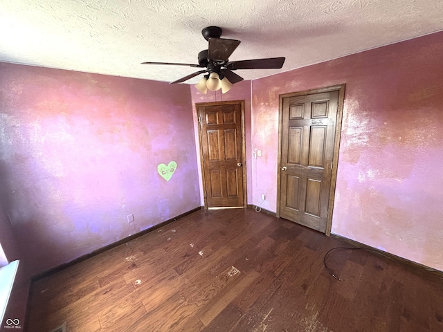 unfurnished bedroom featuring ceiling fan, dark hardwood / wood-style flooring, and a textured ceiling