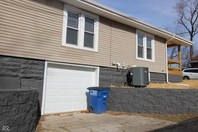 view of home's exterior featuring cooling unit and a garage