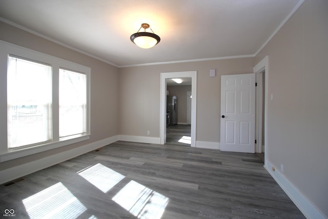 unfurnished room featuring crown molding and dark wood-type flooring