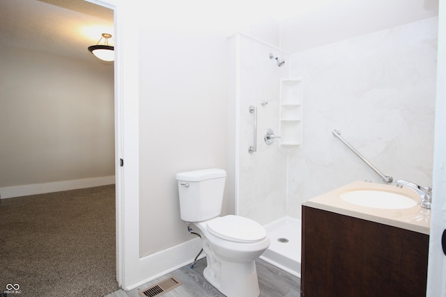 bathroom with vanity, a shower, and toilet