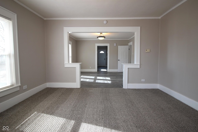 carpeted foyer featuring crown molding and a wealth of natural light