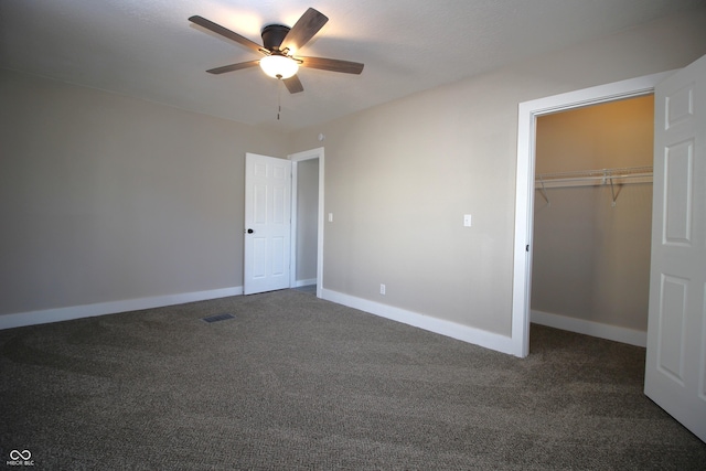 unfurnished bedroom with ceiling fan, dark carpet, and a closet