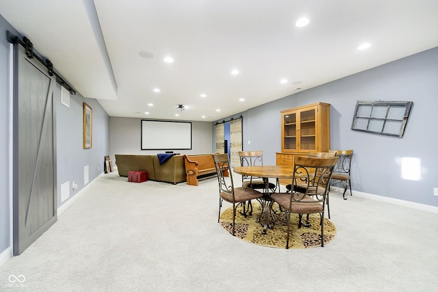 carpeted dining space featuring a barn door