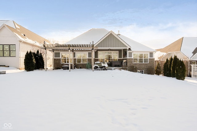 snow covered property with a pergola