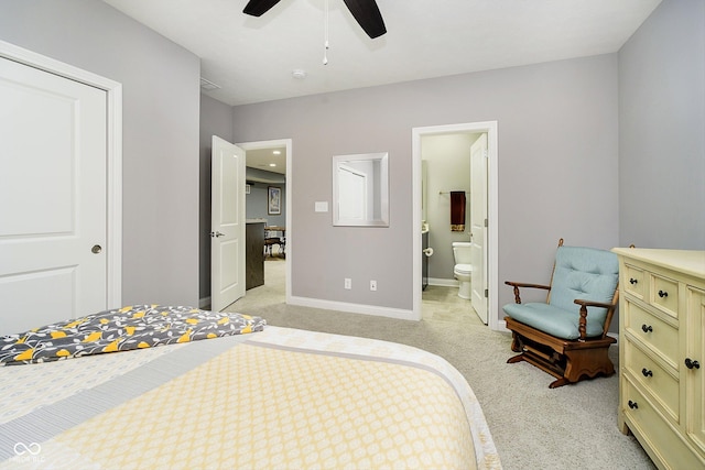 bedroom featuring light colored carpet, ceiling fan, and ensuite bathroom