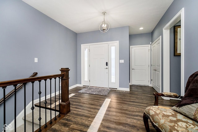 foyer entrance with dark hardwood / wood-style floors and a notable chandelier