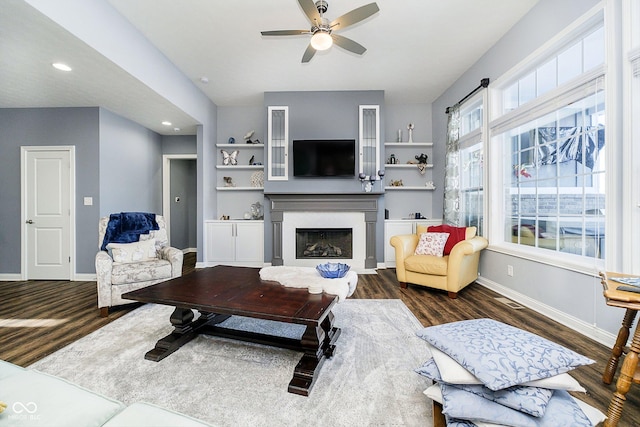 living room with dark wood-type flooring and ceiling fan