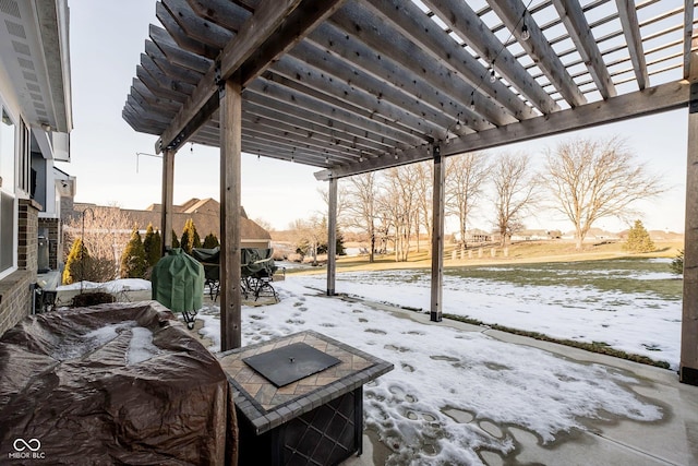 snow covered patio with a pergola and a fire pit