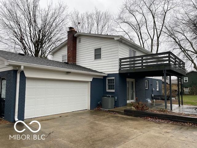 view of side of home with central AC and a garage