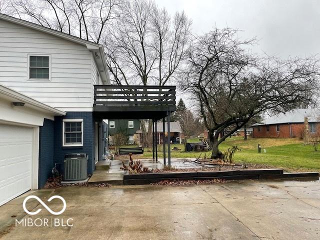 view of patio / terrace with cooling unit, a garage, and a deck