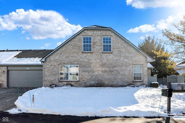 view of snowy exterior featuring a garage