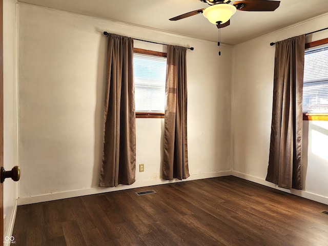 empty room with wood finished floors, visible vents, and a wealth of natural light