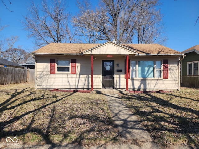 view of front facade featuring a front yard and fence