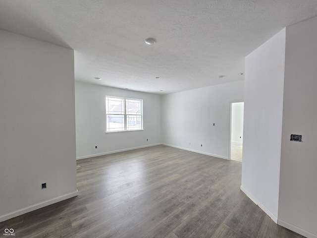 unfurnished room featuring dark hardwood / wood-style floors and a textured ceiling