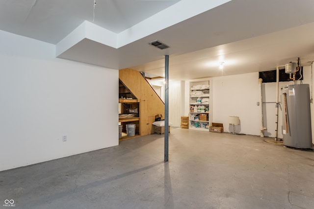 basement featuring built in shelves and water heater