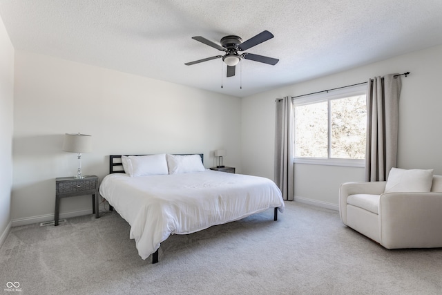 carpeted bedroom with ceiling fan and a textured ceiling