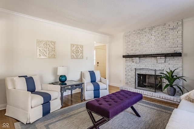 living room featuring a textured ceiling, ornamental molding, a fireplace, and hardwood / wood-style flooring