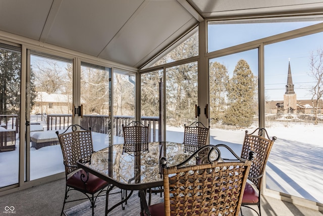 sunroom / solarium featuring a healthy amount of sunlight and vaulted ceiling