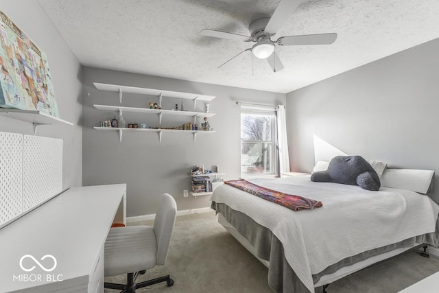 bedroom with ceiling fan, carpet floors, and a textured ceiling