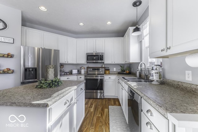 kitchen featuring hanging light fixtures, white cabinetry, appliances with stainless steel finishes, and sink