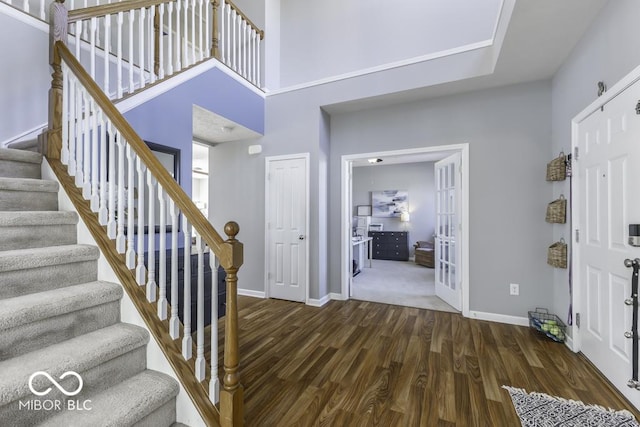 entryway with a towering ceiling and dark hardwood / wood-style flooring