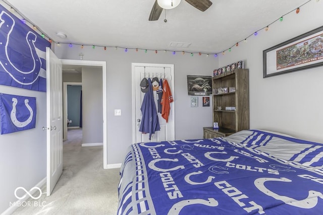 bedroom with light colored carpet, ceiling fan, and a closet