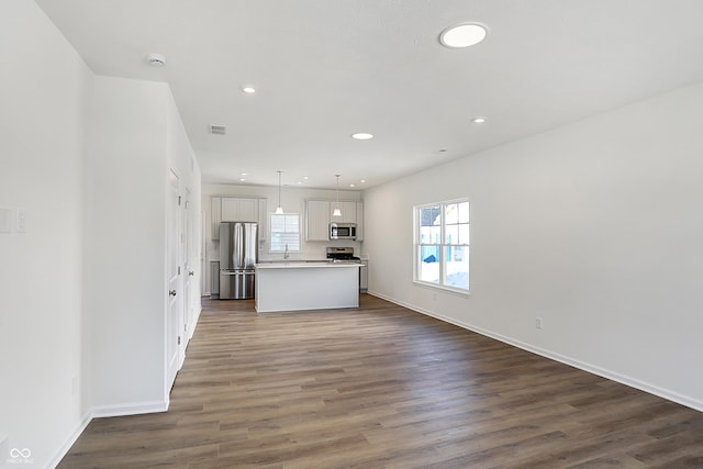 kitchen with stainless steel appliances, dark hardwood / wood-style floors, hanging light fixtures, a kitchen island, and white cabinets